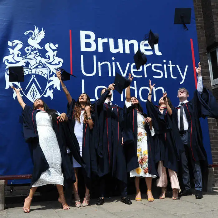 group of graduating students in front of a large СʪƵ sign(1)